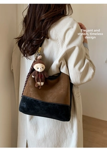 Dettaglio borsa hobo bicolore in pelle scamosciata con ciondolo a forma di orsetto carino