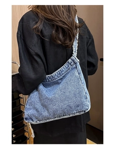Dettaglio della borsa a tracolla in denim con tracolla sfilacciata e lavaggio vintage