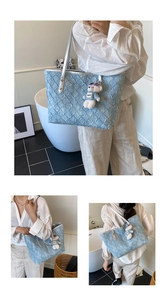 Detail of light blue denim tote bag with ruched texture and cute bear charm pendant
