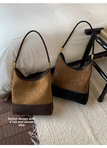 Dettaglio di borse a secchiello vintage in pelle scamosciata con design bicolore marrone e kaki