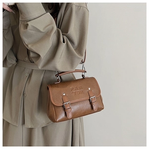 Detail shot of brown vintage handbag with PAN TOR embossing and metallic buckle design