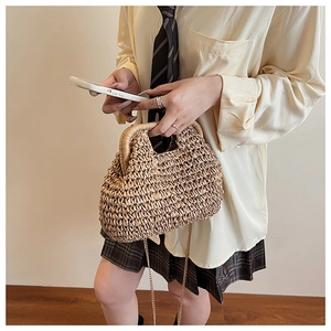 Détail du sac en paille tressé à la main montrant la fibre naturelle et la chaîne en métal