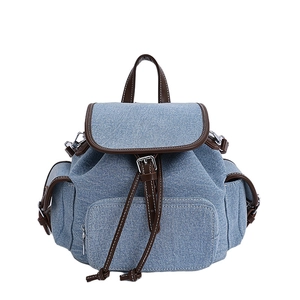 Zaino in tela denim con finiture in pelle marrone e chiusura retrò con coulisse su fondo bianco
