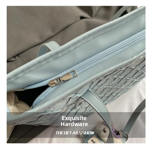 Detail showing high-quality metal zipper and blue woven texture of the tote bag