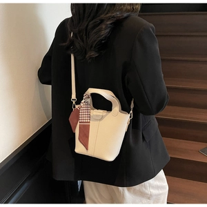 Detail of off-white bucket bag with houndstooth silk scarf and adjustable leather strap