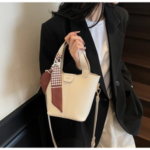 Chic beige bucket bag with litchi grain texture and elegant houndstooth silk scarf detail