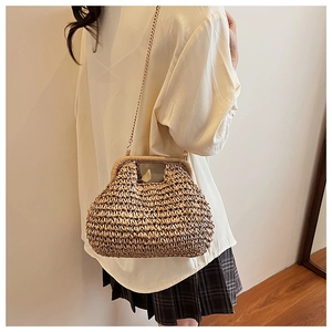 Détail d'un sac en paille fait main avec poignée tissée et bandoulière en chaîne dorée