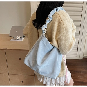 Détail du sac cabas bleu clair à texture nuage avec une bandoulière plissée très tendance