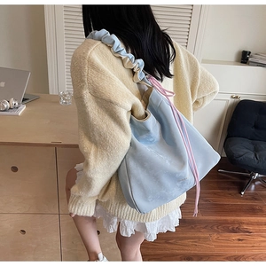 Détail du sac plissé bleu clair avec cordon rose et bandoulière large pour le porter