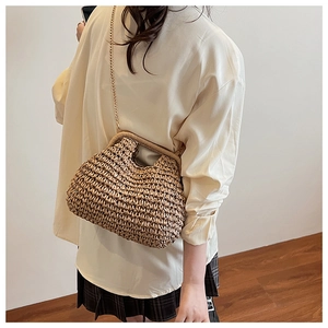 Texture détaillée d'un sac en paille tissé main avec chaîne dorée et poignée chic