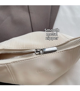 Close-up of cream white leather bag showing silver zipper and Chan'2ab logo embossing