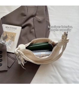 Interior view of off-white leather bag showing large capacity for phones and lipstick