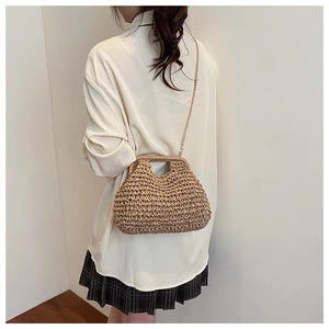 Détail du sac à main en paille tressée avec chaîne dorée et poignée en bois pour plage