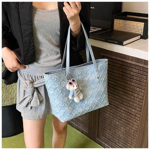 Light blue woven tote bag with 3D wave texture and a cute teddy bear charm detail