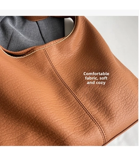 Detail einer braunen Shopper-Tasche aus weichem Leder mit feinen Nähten und Stofffutter