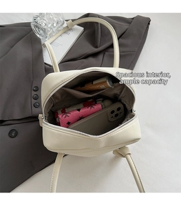 Interior view of cream leather tote showing large capacity with phone and cosmetics