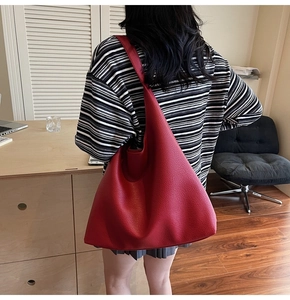 Dettaglio della borsa tote in pelle martellata rossa con interno ampio e tracolla chic