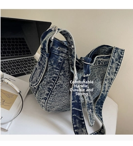 Macro detail of washed denim fabric with metallic eyelets and silver ring on a tote bag