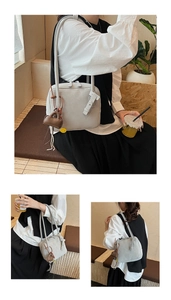 Detailed views of light grey suede tote bag with brown mini charm in casual cafe setting