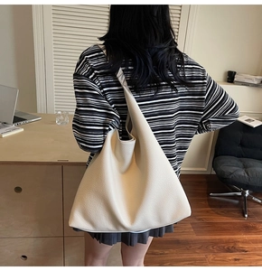 Dettaglio della borsa hobo bianco crema con trama in pelle martellata e ampia tracolla
