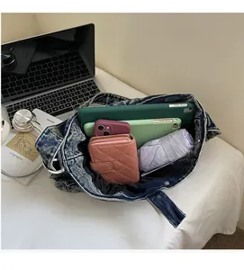 Interior view showing large capacity of denim tote bag with tablet and daily essentials