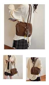 Close-up of vintage dark brown tote bag with contrast stitching and decorative charms