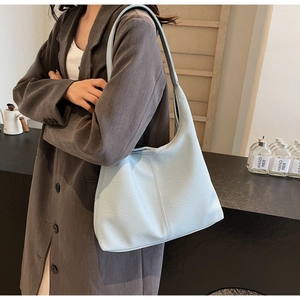 Detail of light blue textured tote bag showing pebbled leather finish and soft hobo structure