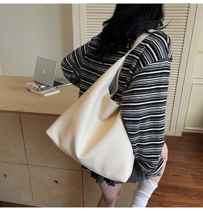 Texture dettagliata della borsa tote oversize beige in similpelle in un ambiente casual