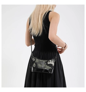 Detail of camouflage crossbody bag with cross pendant and skull charm in punk style