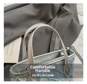 Close-up of light blue denim bucket bag with pleated texture and silver metallic handle