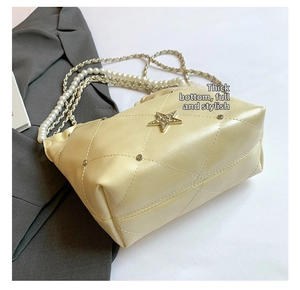 Détail du sac seau matelassé avec ornement en étoile et bandoulière en perles