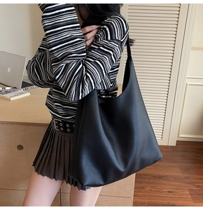 Dettaglio della texture in pelle martellata nera di una grande borsa hobo da donna