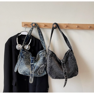 Detail of vintage washed denim tote bags with metallic eyelets and leather straps