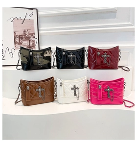 Detalle de bolsos punk con cruces metálicas y cremalleras en forma de calavera