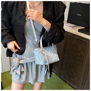 Light blue pleated mini crossbody bag with silver tassel shown on model in black blazer