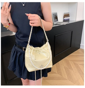 Détail du sac seau matelassé jaune crème avec perles et breloque en forme d'étoile