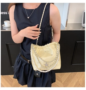 Détail du sac nuage matelassé jaune clair avec chaîne en perles et pendentif étoile