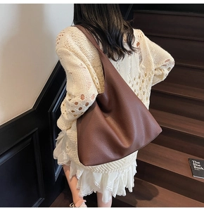 Grande borsa tote marrone scuro in pelle martellata indossata sulla spalla