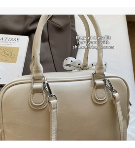 Dettaglio della borsa Boston crema con finiture argento e sciarpa di seta a pois chic