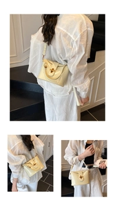 Detail der cremefarbenen Lackleder-Beuteltasche mit Glanzeffekt und Goldverschluss
