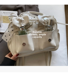 Dettaglio borsa in pelle PU bianco crema con tasche anteriori e sciarpa a pois