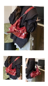 Détail du sac fourre-tout en cuir verni rouge avec boucle réglable et texture brillante