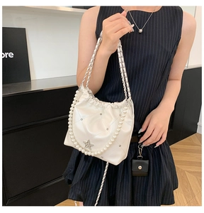 Détail du sac seau matelassé blanc avec grande chaîne de perles et breloque étoile
