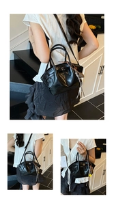 Detail of black dumpling bag with pleated texture and stylish braided tassel charm