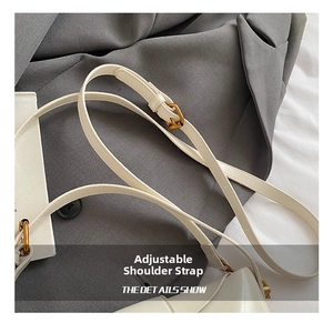 Detail der weißen Ledertasche mit verstellbarem Schultergurt und goldener Metallschnalle