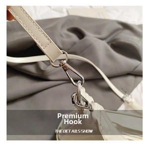Detail of white crocodile texture leather strap with polished silver metal hook buckle