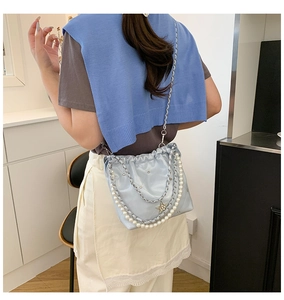 Détail du sac seau matelassé bleu clair avec chaîne en perles et pendentif étoile