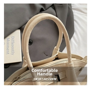 Close-up of cream beige dumpling bag featuring reinforced round handles and zip closure