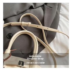 Detail showing the adjustable shoulder strap with metal buckle on the beige leather bag
