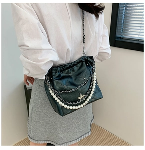 Détail du sac à bandoulière noir matelassé avec grosses perles et pendentif étoile strass